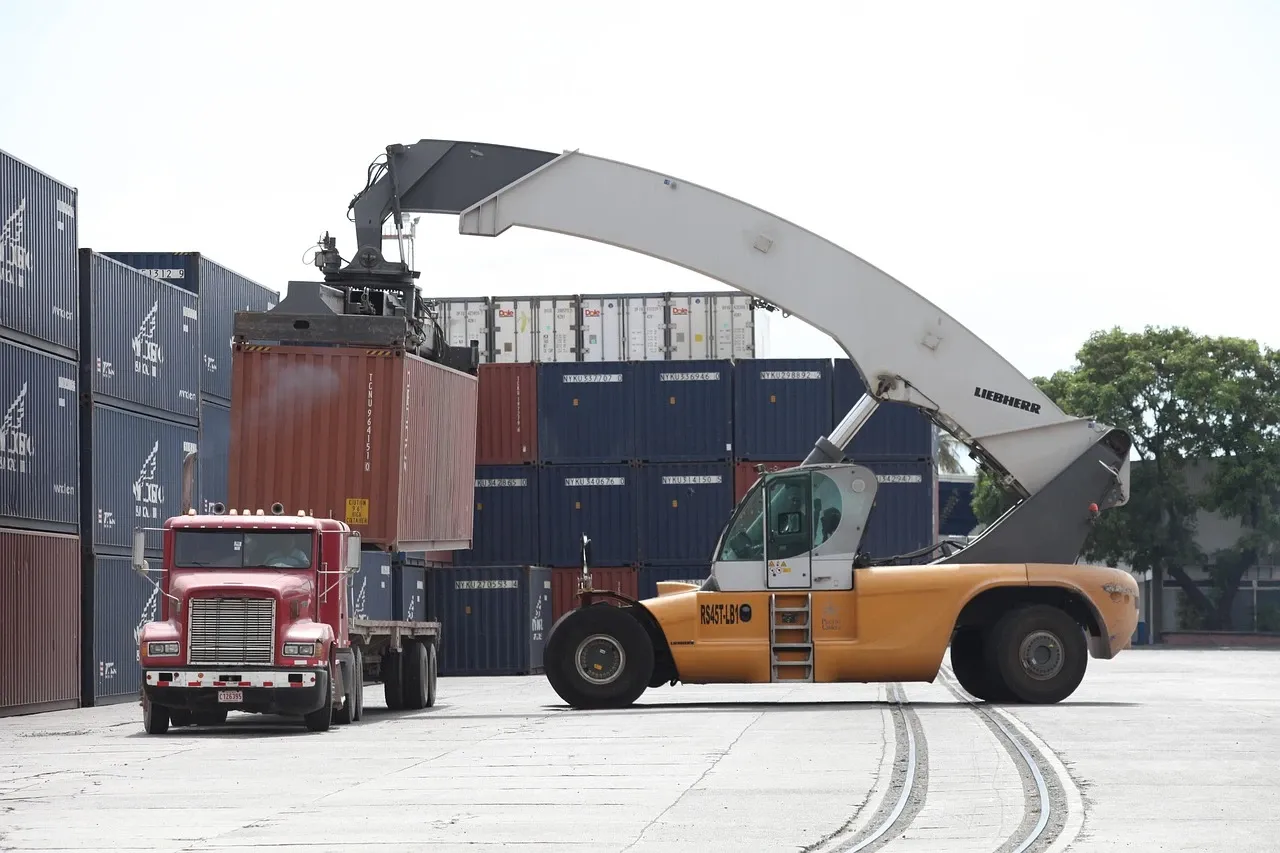 20-foot container being set onto a chassis behind a Freightliner truck